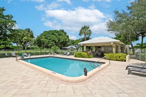 a view of a house with swimming pool and sitting area