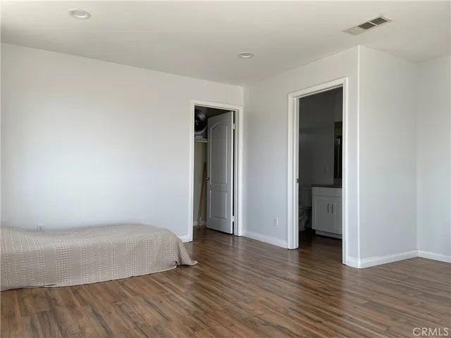 an empty room with wooden floor and closet