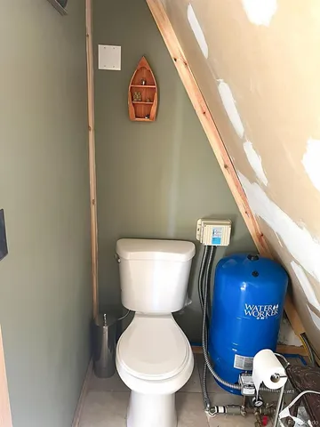 a toilet sitting in a bathroom next to a wooden wall