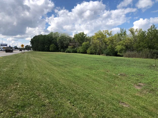 a view of a big yard with a house in the background