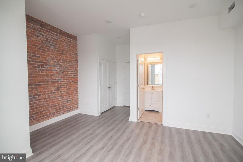 1829 North 33rd Street, Unit 1 Philadelphia, PA 19121 - Photo 3 of 9 an empty room with wooden floor and windows