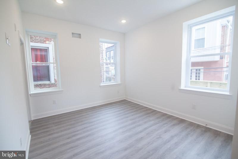 1829 North 33rd Street, Unit 1 Philadelphia, PA 19121 - Photo 6 of 9 an empty room with wooden floor and windows