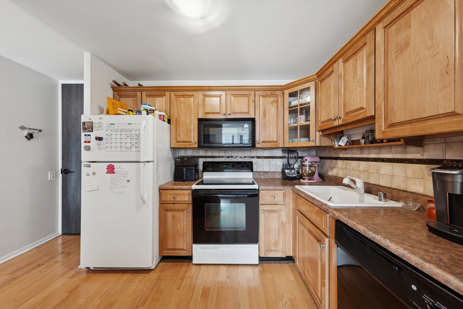 1030 North State Street, Unit 10K Chicago, IL 60610 - Photo 9 of 17 a kitchen with a sink a microwave a refrigerator and wooden floor
