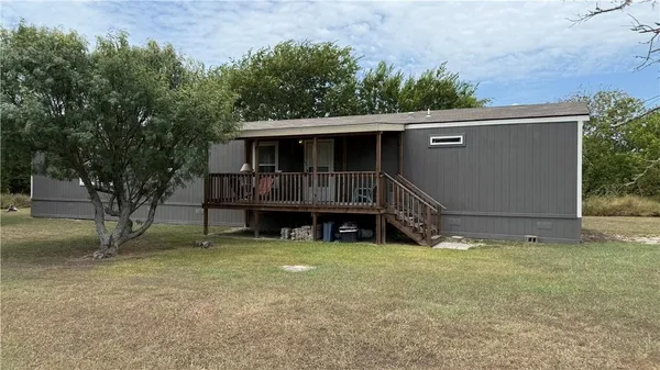 a view of a house with a yard and sitting area