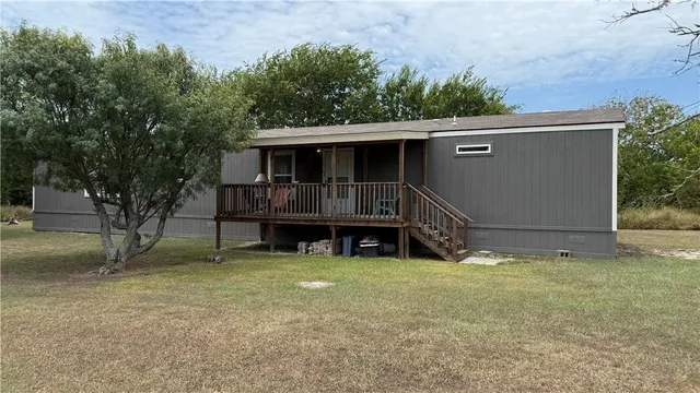 a view of a house with a yard and sitting area