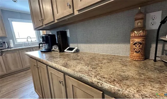 a kitchen with granite countertop a sink a stove and cabinets