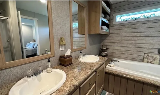 a bathroom with a granite countertop sink a toilet and mirror