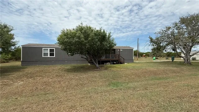 a view of a house with backyard and tree