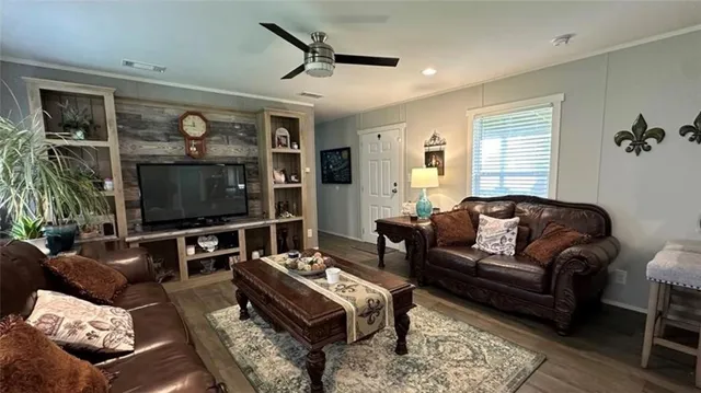 a living room with furniture a flat screen tv and a window