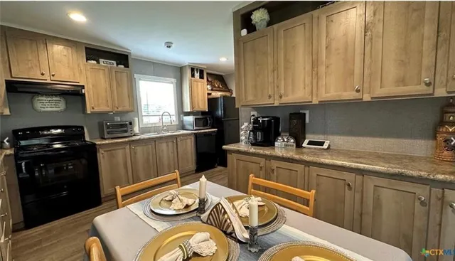 a kitchen with stainless steel appliances granite countertop a sink dishwasher stove and cabinets