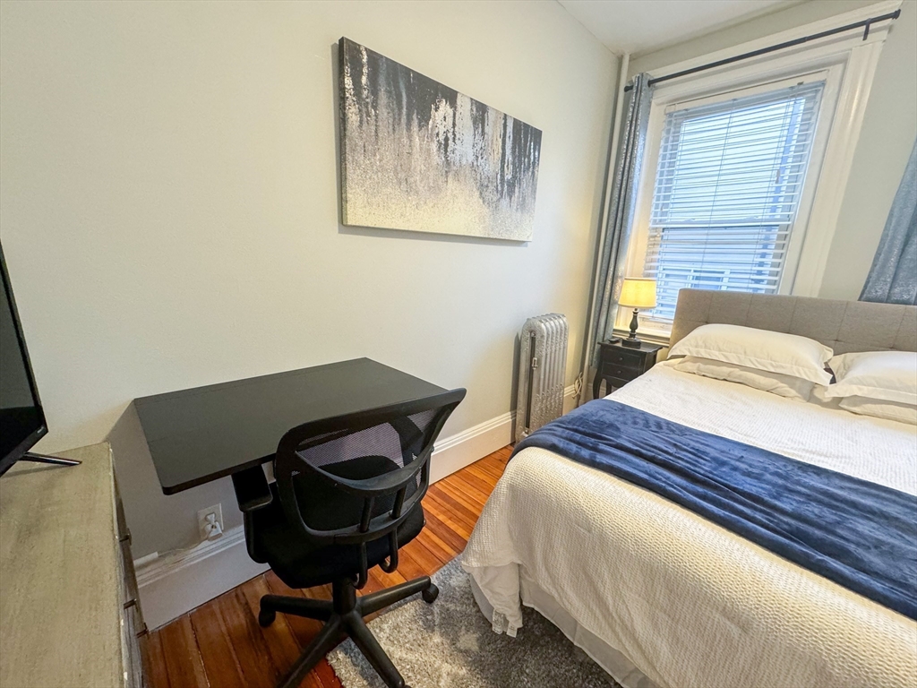 636 Washington Street, Unit 1 Brookline, MA 02446 - Photo 12 of 17 a bedroom with a bed and a window