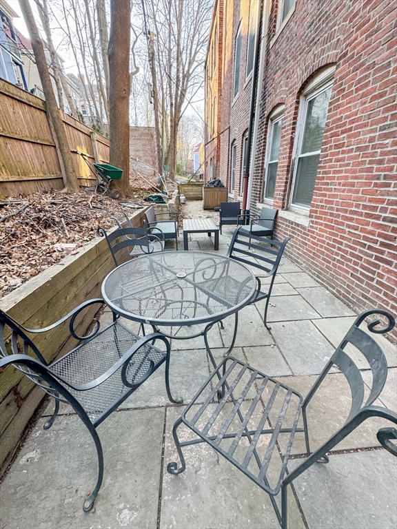 636 Washington Street, Unit 1 Brookline, MA 02446 - Photo 17 of 17 a backyard of a house with table and chairs