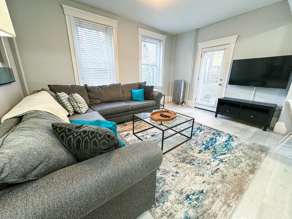 636 Washington Street, Unit 1 Brookline, MA 02446 - Photo 2 of 17 a living room with furniture and a flat screen tv