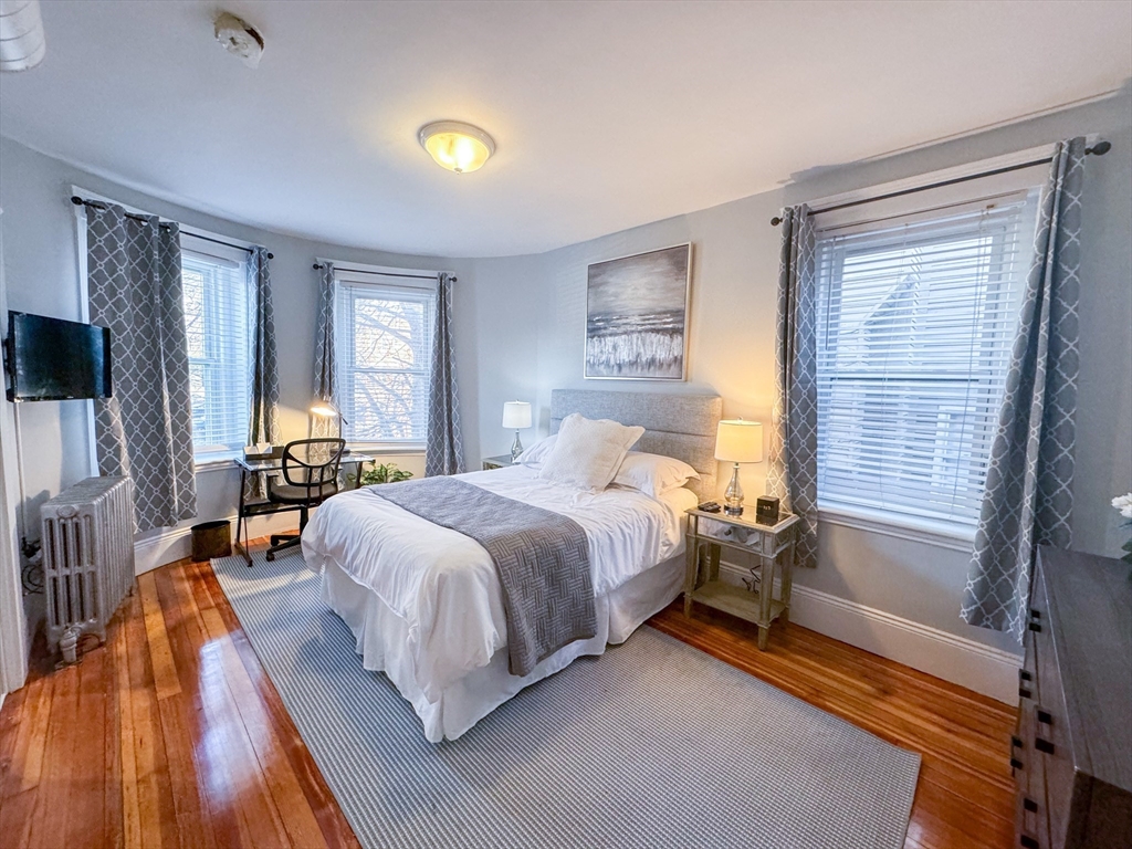 636 Washington Street, Unit 1 Brookline, MA 02446 - Photo 7 of 17 a bedroom with a bed and large windows