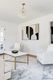 a living room with couches and a dining table with wooden floor