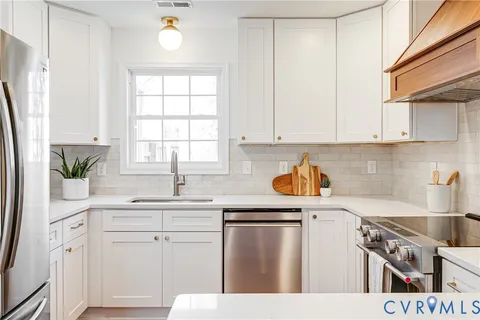 a kitchen with a sink dishwasher a stove and a refrigerator with wooden floor