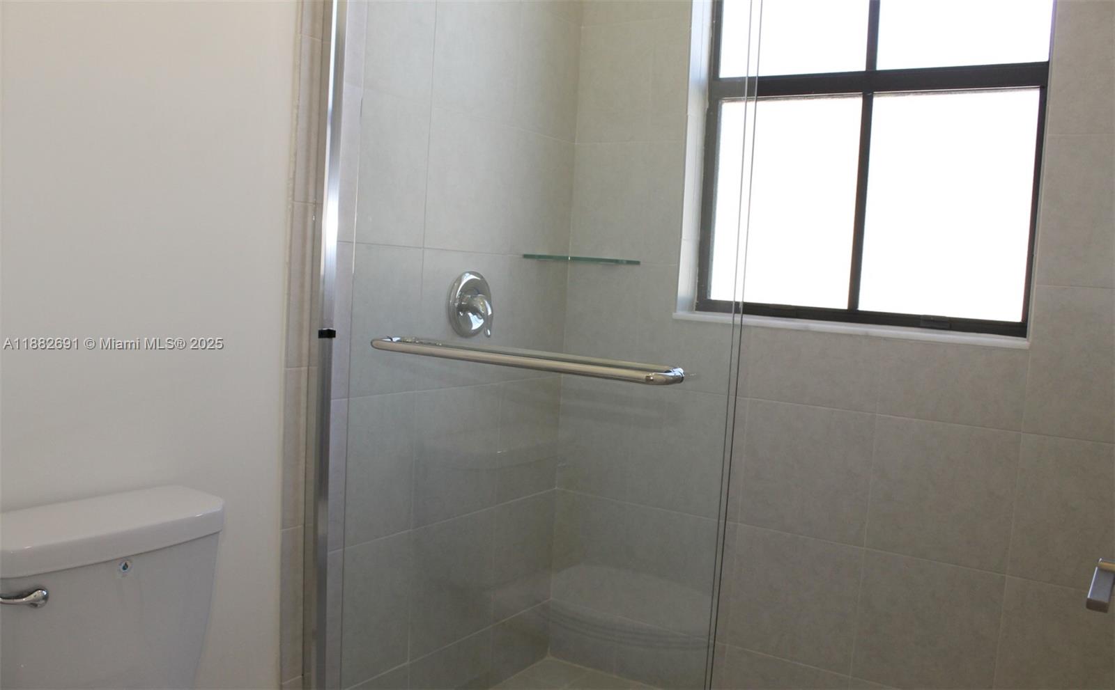 11100 West 33rd Way, Unit 11100 Hialeah, FL 33018 - Photo 21 of 26 a bathroom with a glass shower door