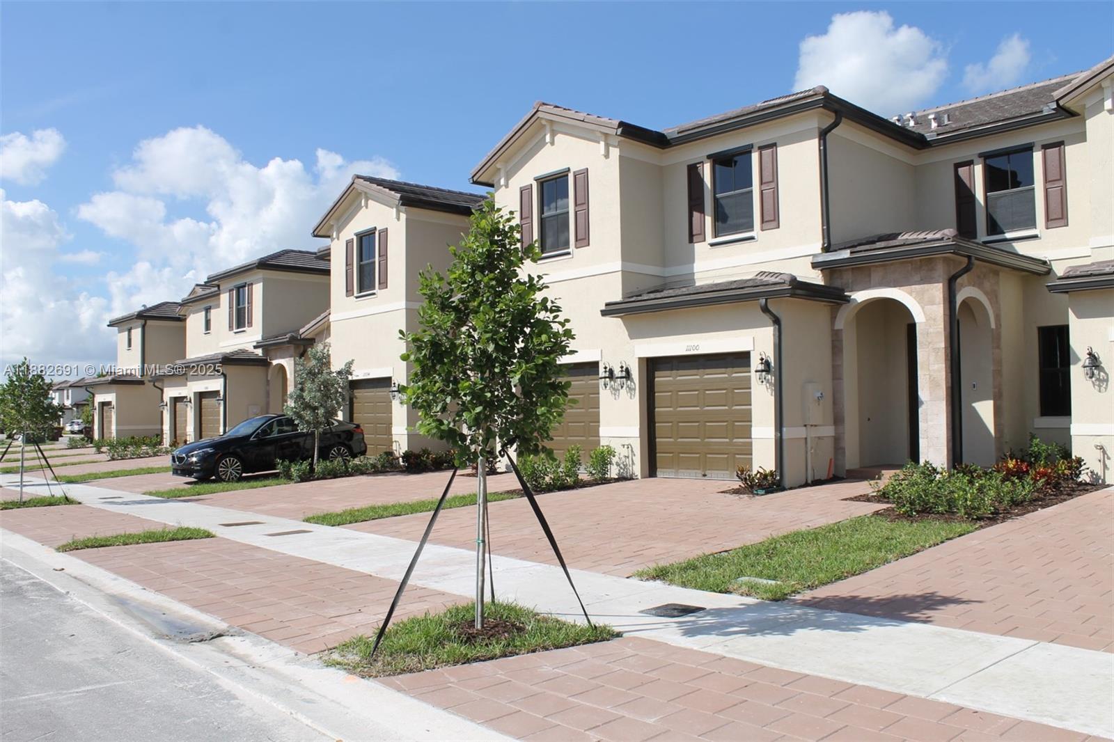 11100 West 33rd Way, Unit 11100 Hialeah, FL 33018 - Photo 23 of 26 a front view of a house with a yard and trees
