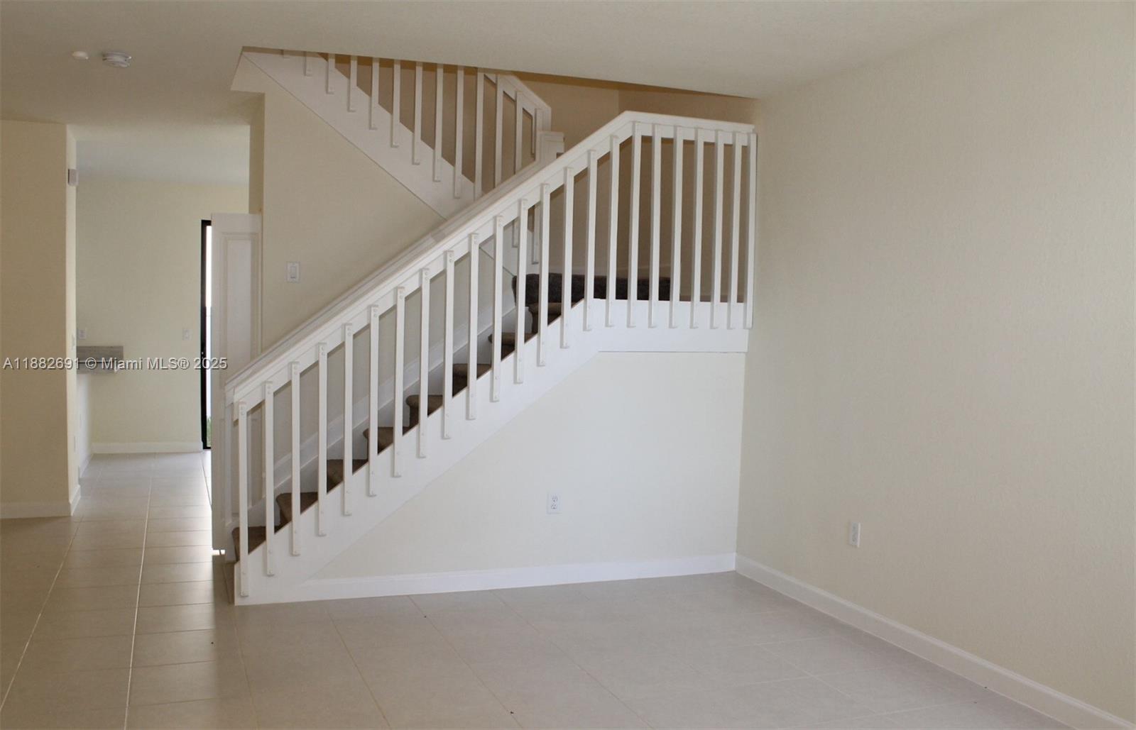 11100 West 33rd Way, Unit 11100 Hialeah, FL 33018 - Photo 4 of 26 a view of staircase with railing and white walls