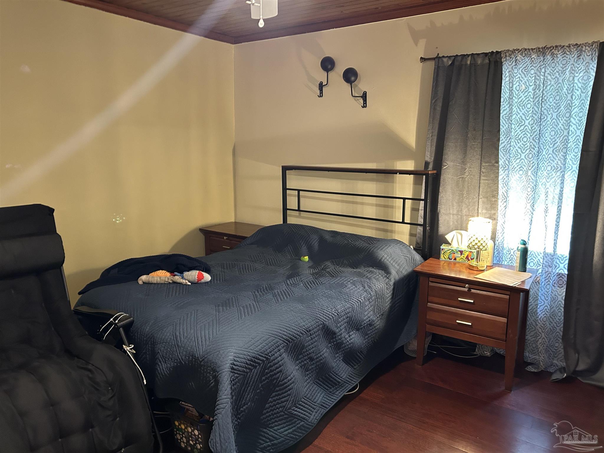 6500 Sanders Street Milton, FL 32570 - Photo 9 of 16 a bedroom with a bed and wooden floor