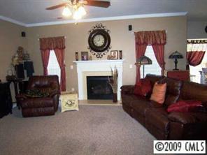5522 Alexandrite Way Fort Mill, SC 29708 - Photo 4 of 8 a living room with furniture a clock and a fireplace