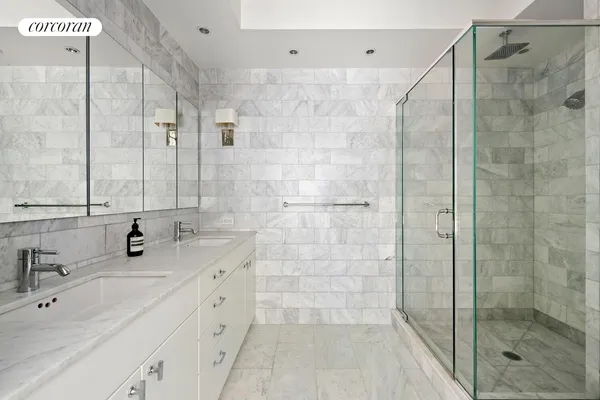 a bathroom with a double vanity sink mirror and shower