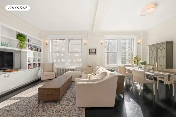 a living room with furniture a flat screen tv and large windows