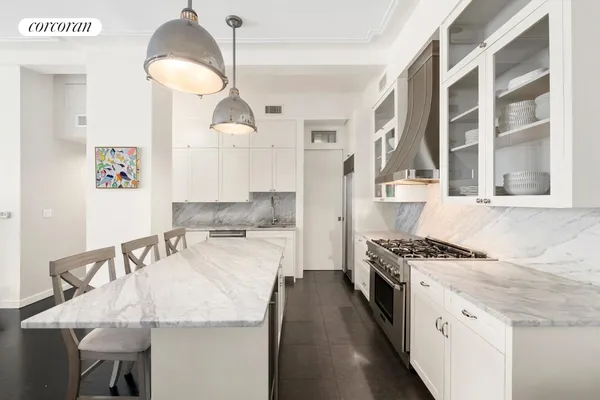 a kitchen with granite countertop a sink a stove and chairs