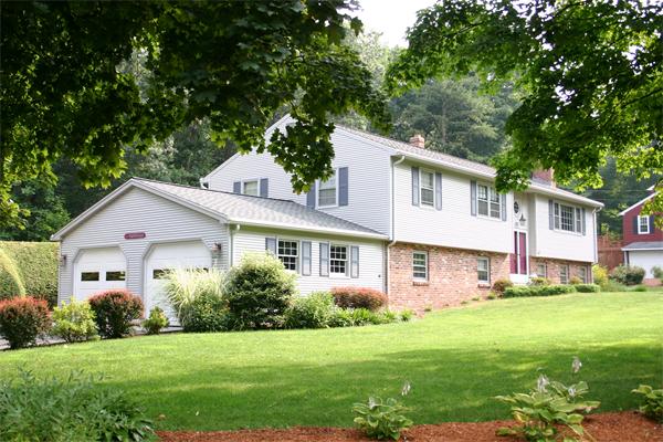 a front view of a house with a yard and trees