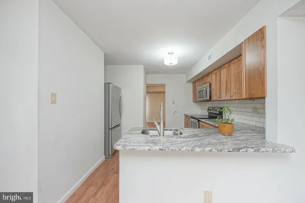 a kitchen with a sink a refrigerator and wooden cabinets