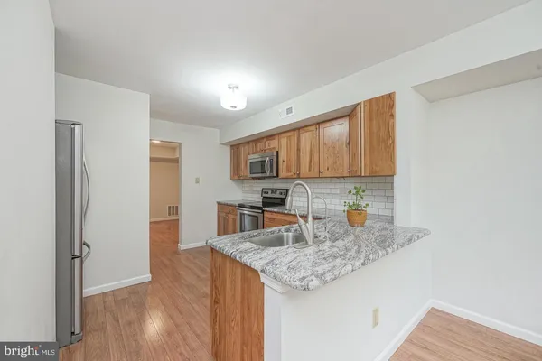 a kitchen with granite countertop kitchen island a sink appliances and cabinets