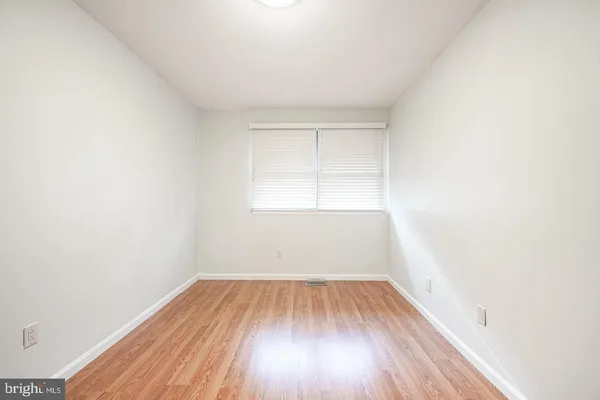 a view of a room that has wooden floor and white walls