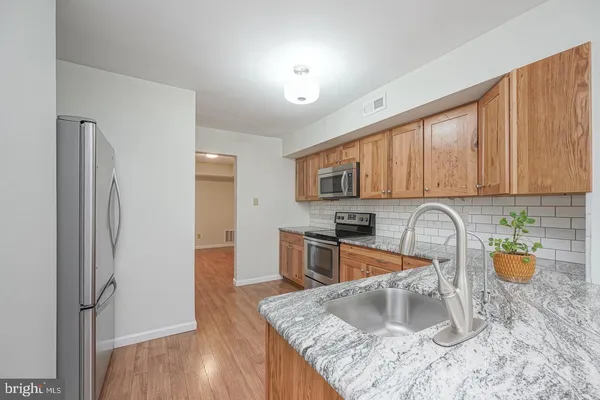 a kitchen with stainless steel appliances granite countertop a refrigerator sink and stove