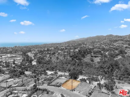 an aerial view of a residential houses with city view