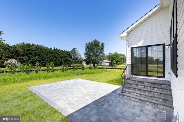 a view of a house with a big yard and potted plants