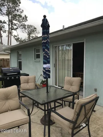 a backyard of a house with table and chairs