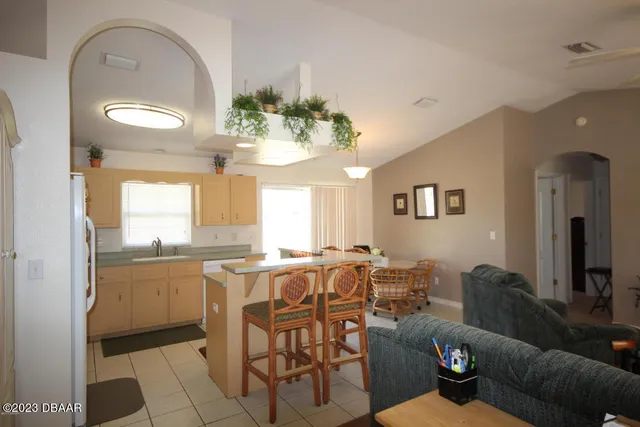 a living room with furniture a chandelier and a dining table