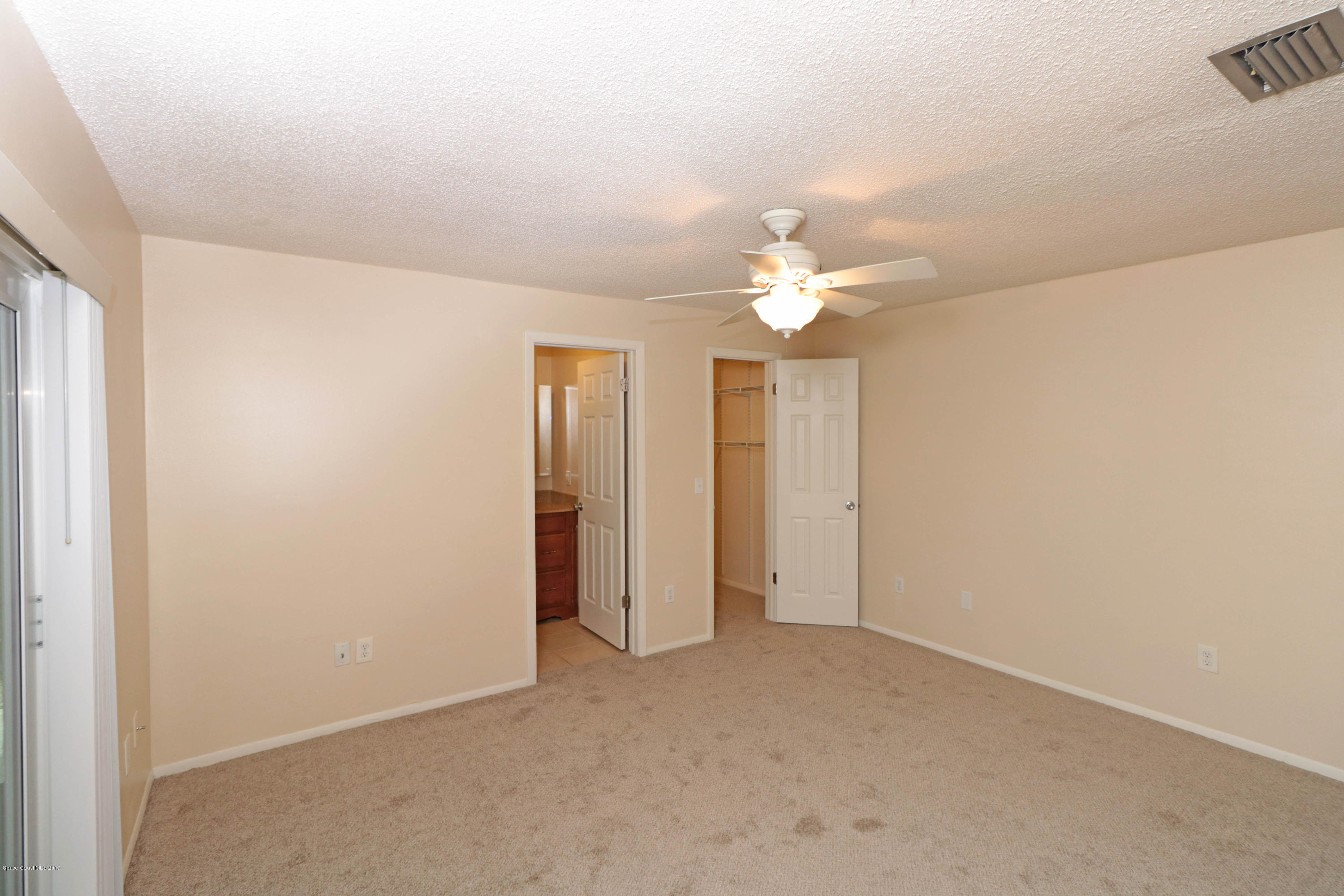 243 Ocean View Lane Melbourne, FL 32903 - Photo 14 of 18 an empty room with a bathroom and a chandelier fan