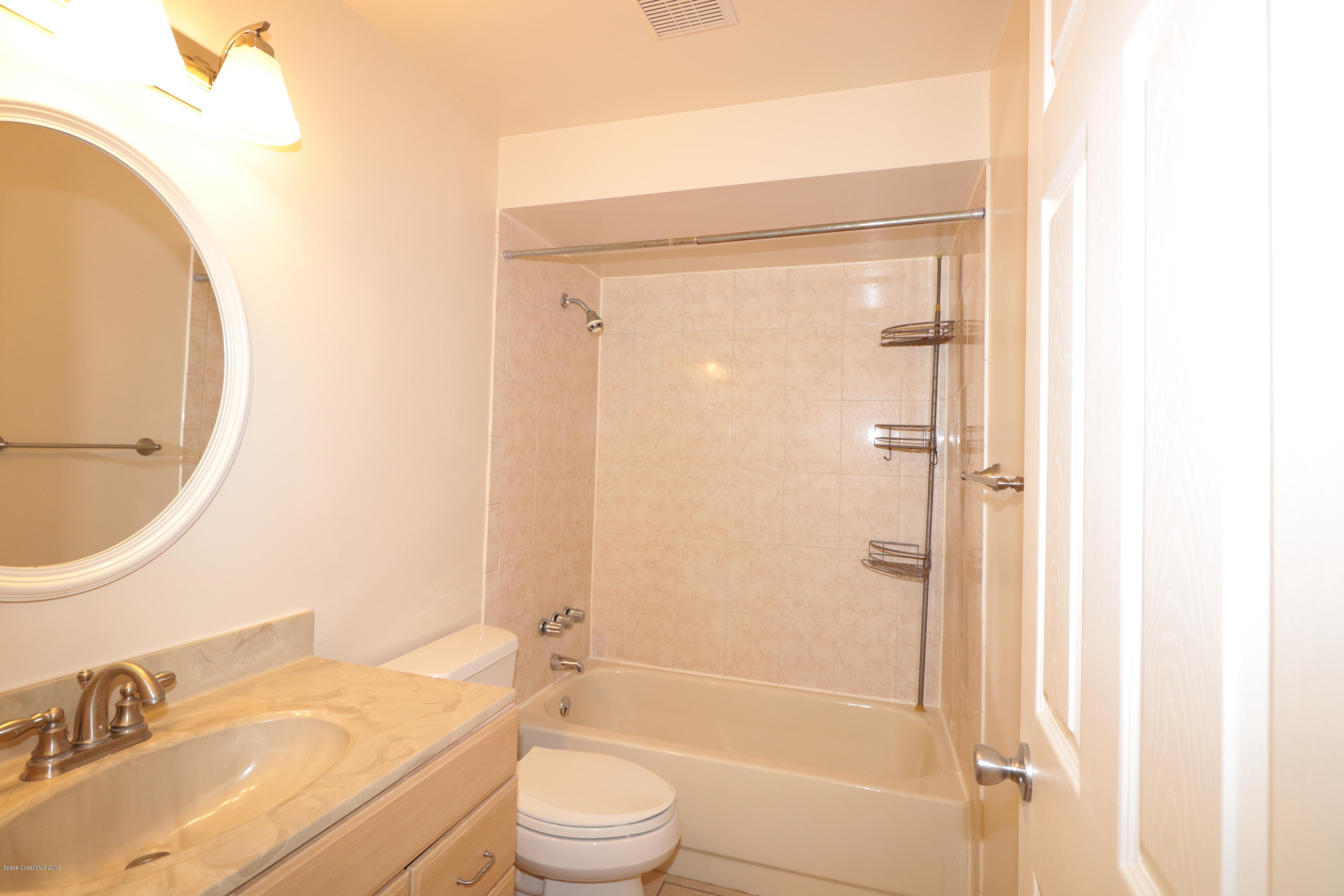 243 Ocean View Lane Melbourne, FL 32903 - Photo 18 of 18 a bathroom with a granite countertop sink toilet and shower