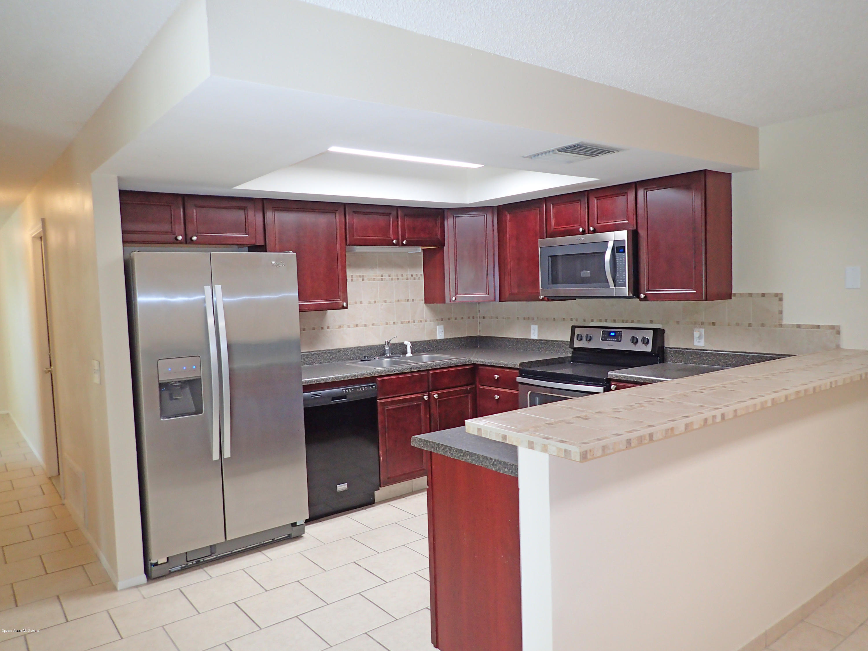 243 Ocean View Lane Melbourne, FL 32903 - Photo 2 of 18 a kitchen with stainless steel appliances granite countertop a refrigerator sink and stove