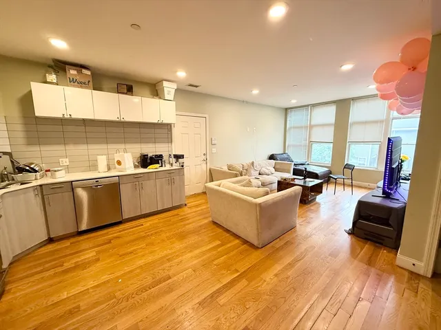 a large room with kitchen island a large window and a sink