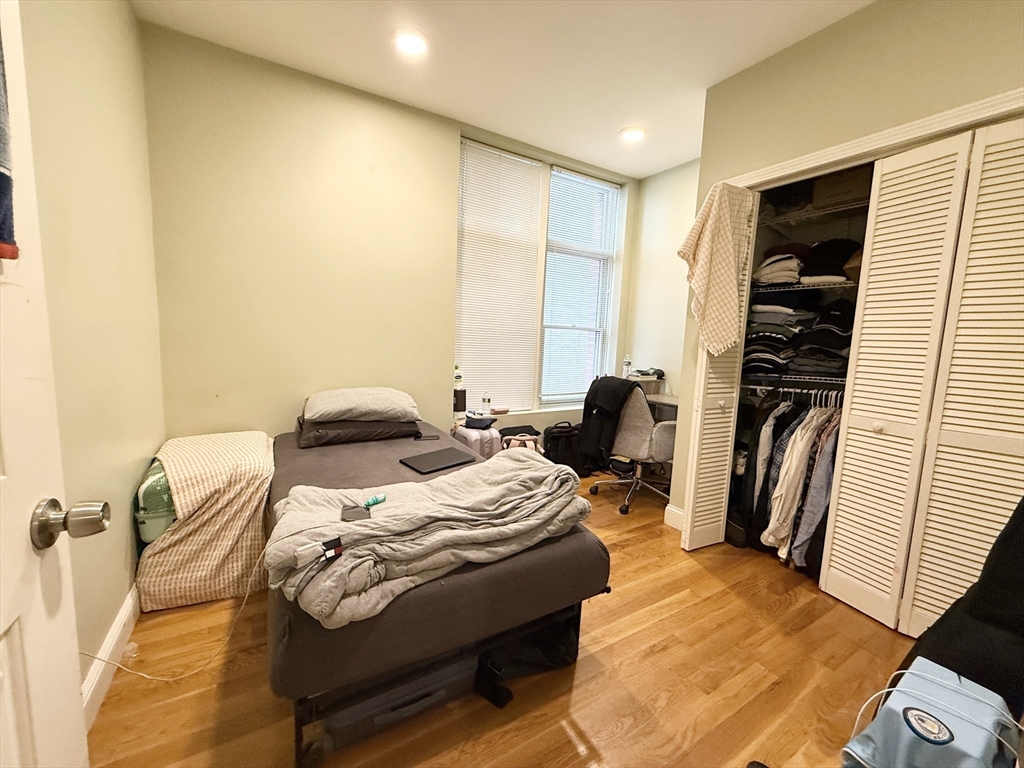 299 Dudley Street, Unit 4 Boston, MA 02119 - Photo 5 of 6 a bedroom with a bed and wooden floor