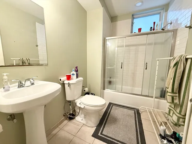 a bathroom with a sink a toilet a mirror and shower