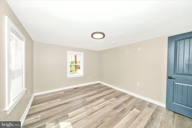 a view of empty room with wooden floor