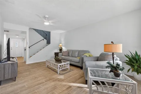 a living room with furniture and a wooden floor