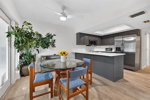 a kitchen with a table chairs refrigerator and microwave