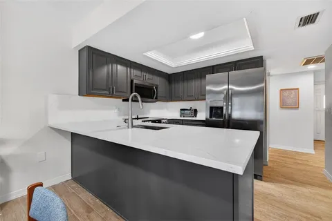 a kitchen with kitchen island a sink appliances and cabinets