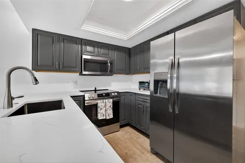 a kitchen with granite countertop a refrigerator and a stove top oven