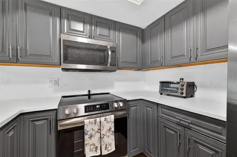 a kitchen with stainless steel appliances granite countertop a sink a stove a microwave oven with cabinets