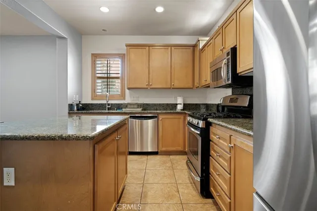 a kitchen with granite countertop a sink a counter top space and cabinets